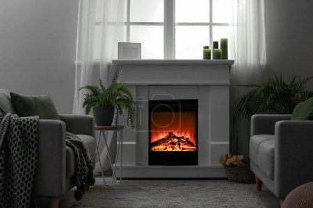 Foto de Interior of modern living room with electric fireplace and armchair - Imagen libre de derechos