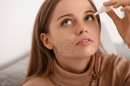 Foto de Mujer joven usando gotas para los ojos en casa, primer plano - Imagen libre de derechos
