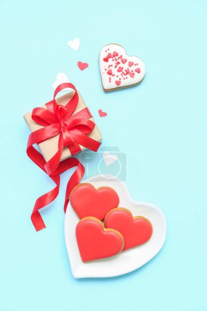 Foto de Composition with tasty heart shaped cookies and gift box on color background. Valentine's Day celebration - Imagen libre de derechos