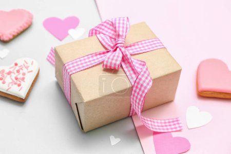 Foto de Gift box and tasty heart shaped cookies on color background. Valentine's Day celebration - Imagen libre de derechos