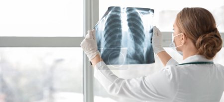 Photo for Female doctor with x-ray image of lungs in clinic - Royalty Free Image