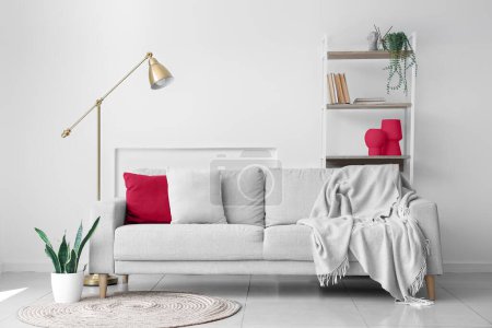 Téléchargez les photos : Interior of light living room with shelving unit, sofa and lamp - en image libre de droit