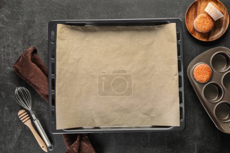 Photo for Baking trays with muffins and utensils on dark background - Royalty Free Image