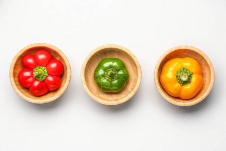 Foto de Wooden bowls with different bell peppers on white background - Imagen libre de derechos