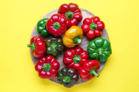 Foto de Plate with fresh bell peppers on yellow background - Imagen libre de derechos