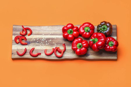 Foto de Wooden board of fresh bell peppers on color background - Imagen libre de derechos