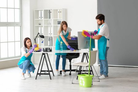 Photo for Young janitors cleaning in modern office - Royalty Free Image