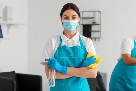 Téléchargez les photos : Female janitor with medical mask, rag and detergent in office - en image libre de droit