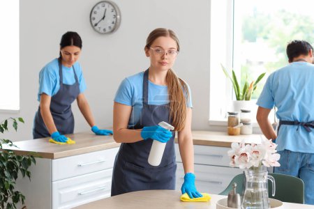 Photo for Young janitors cleaning in kitchen - Royalty Free Image