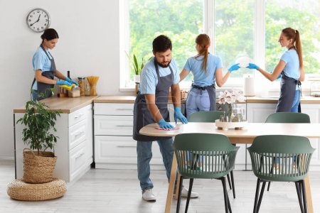 Téléchargez les photos : Young janitors cleaning in kitchen - en image libre de droit
