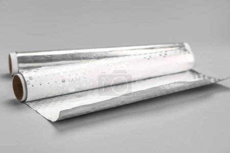 Téléchargez les photos : Rolls of aluminium foil on grey background - en image libre de droit