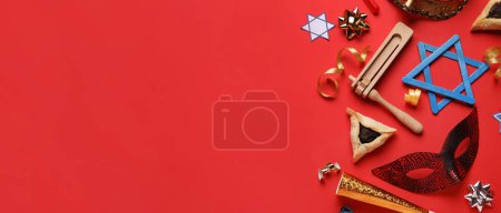 Foto de David star, hamantaschen cookie, carnival mask and rattle for Purim holiday on red background with space for text - Imagen libre de derechos