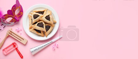 Foto de Hamantaschen cookies, carnival mask and rattles for Purim holiday on pink background with space for text - Imagen libre de derechos