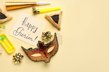 Foto de Card with text HAPPY PURIM, Hamantaschen cookies, carnival mask and noise makers on yellow background - Imagen libre de derechos