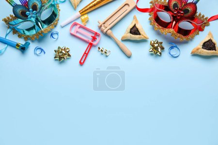 Téléchargez les photos : Hamantaschen cookies, carnival masks and rattles for Purim holiday on blue background - en image libre de droit