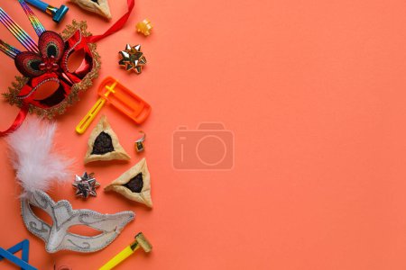 Foto de Hamantaschen cookies, carnival masks and noisemakers for Purim holiday on red background - Imagen libre de derechos