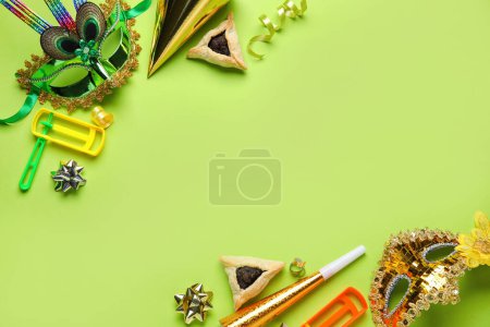 Foto de Frame made of Hamantaschen cookies, carnival masks and rattles for Purim holiday on green background - Imagen libre de derechos