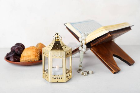 Téléchargez les photos : Lantern with Koran and treats on white background. Islamic New Year celebration - en image libre de droit