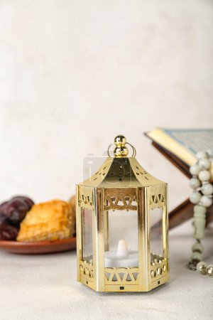 Téléchargez les photos : Lantern with Koran and treats on white background, closeup. Islamic New Year celebration - en image libre de droit
