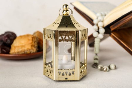 Téléchargez les photos : Lantern with Koran and treats on white background, closeup. Islamic New Year celebration - en image libre de droit