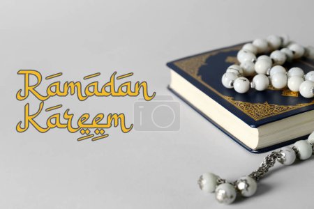 Foto de Greeting card for Ramadan with Koran and prayer beads on light background - Imagen libre de derechos