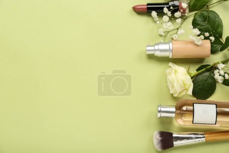 Téléchargez les photos : Composition avec différents cosmétiques, pinceau de maquillage et fleurs sur fond vert - en image libre de droit