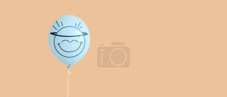 Téléchargez les photos : Ballon à air avec émoticône heureux dessiné sur fond beige avec espace pour le texte - en image libre de droit
