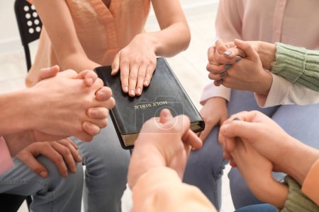 Téléchargez les photos : Group of people praying with Holy Bible in room, closeup - en image libre de droit
