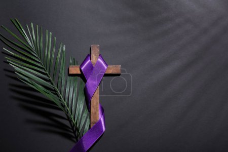 Photo for Cross with purple ribbon and palm leaf on dark background. Good Friday concept - Royalty Free Image