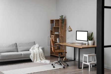 Photo for Interior of light office with table, modern computer and shelving unit - Royalty Free Image