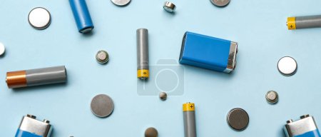 Téléchargez les photos : Different batteries on light blue background - en image libre de droit