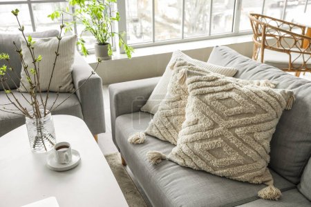 Foto de Sofá gris con cojines elegantes en la sala de estar ligera - Imagen libre de derechos