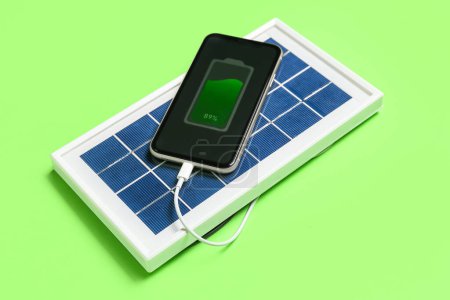 Téléchargez les photos : Panneau solaire portable recharge téléphone portable sur fond vert - en image libre de droit