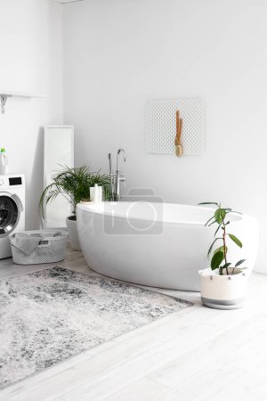 Téléchargez les photos : Intérieur de la salle de bain avec baignoire, plantes d'intérieur et pegboard - en image libre de droit