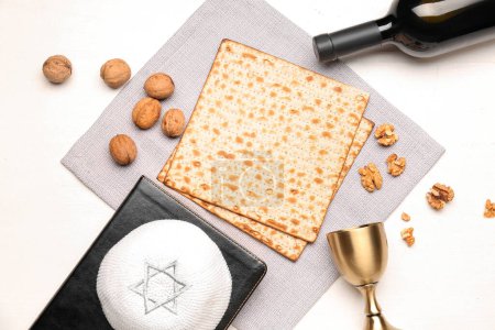 Composition with flatbread matza, walnuts, kippah and cup on light wooden background, closeup