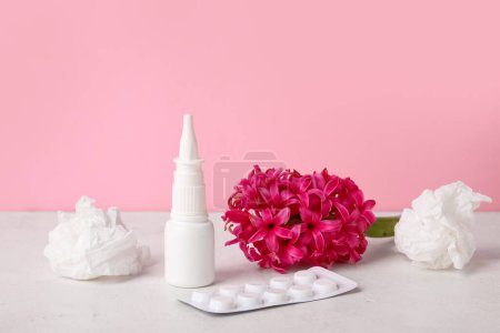 Photo for Nasal drops with pills, flower and tissues on table near pink wall. Seasonal allergy concept - Royalty Free Image