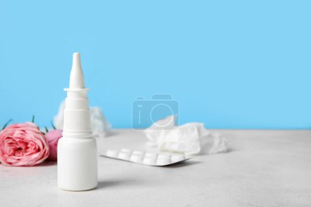Photo for Nasal drops with pills, flowers and tissues on table near blue wall, closeup. Seasonal allergy concept - Royalty Free Image