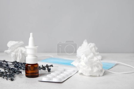Photo for Nasal drops with pills, flowers and tissues on table near grey wall. Seasonal allergy concept - Royalty Free Image