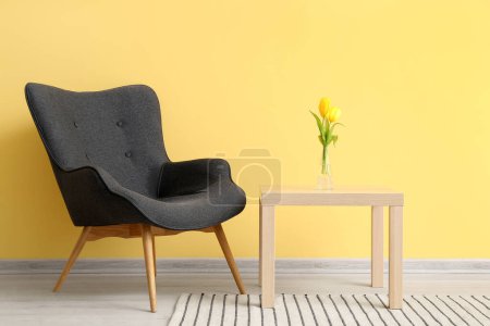 Téléchargez les photos : Fauteuil et table gris moderne près du mur jaune - en image libre de droit