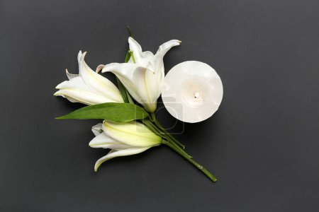 Foto de Vela ardiente y flores de lirio blanco sobre fondo oscuro - Imagen libre de derechos