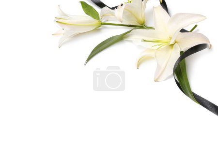 Composition with beautiful lily flowers and black funeral ribbon on white background