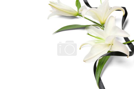 Composición con hermosas flores de lirio y cinta funeraria negra sobre fondo blanco