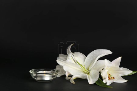 Téléchargez les photos : Bougie ardente et belles fleurs de lys sur fond sombre - en image libre de droit