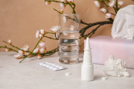 Photo for Nasal drops with pills, tissues and glass of water on table. Seasonal allergy concept - Royalty Free Image