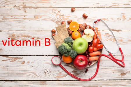 Photo for Plate with healthy products, stethoscope and text VITAMIN B on white wooden background - Royalty Free Image