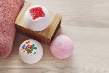 Photo for Different bath bombs on light wooden table - Royalty Free Image