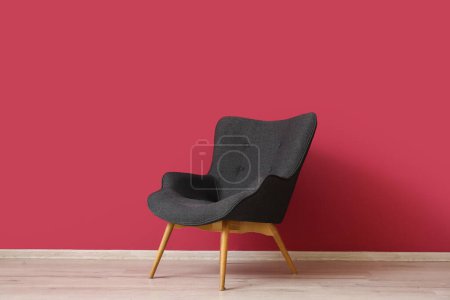 Photo for Black armchair near red wall in room - Royalty Free Image