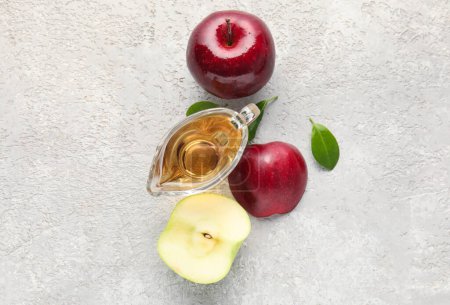 Téléchargez les photos : Bateau à sauce au vinaigre de cidre de pomme frais et fruits sur fond de grunge blanc - en image libre de droit