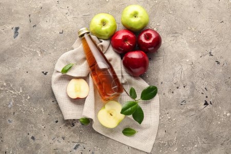 Téléchargez les photos : Bouteille en verre de vinaigre de cidre de pomme frais et de fruits sur fond grunge gris - en image libre de droit