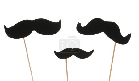 Foto de Conjunto de bigotes de papel negro sobre palos sobre fondo blanco, primer plano - Imagen libre de derechos